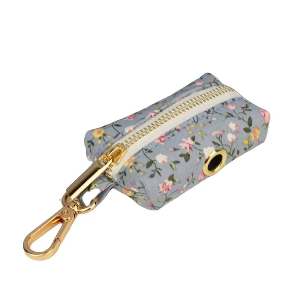 Blue floral patterned adjustable dog collar with matching leash, bow, and vest on a white background.