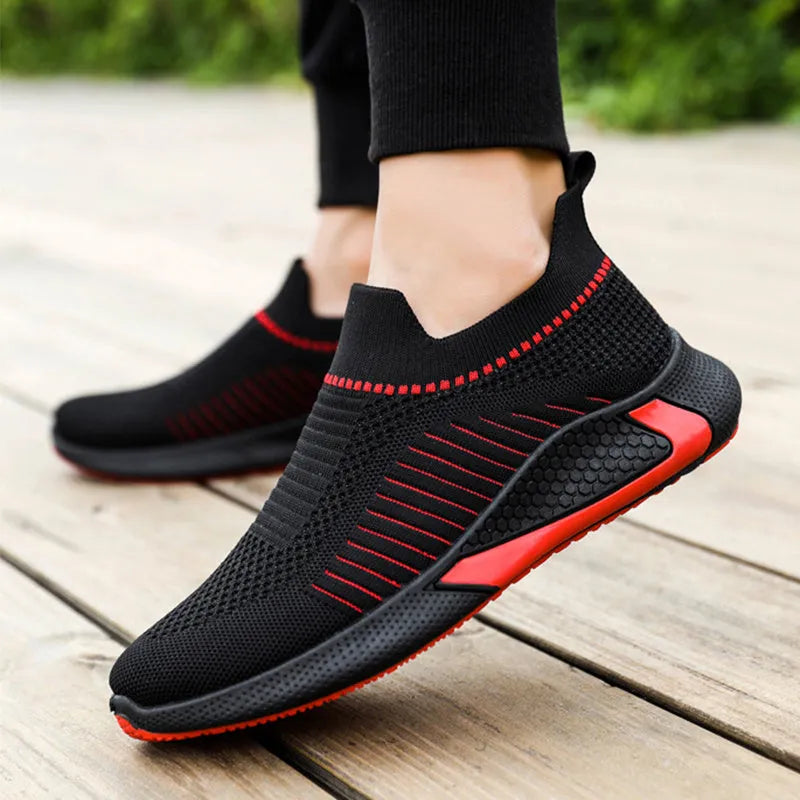 Men's black and white striped mesh slip-on sneakers with flyknit upper and low-cut profile.