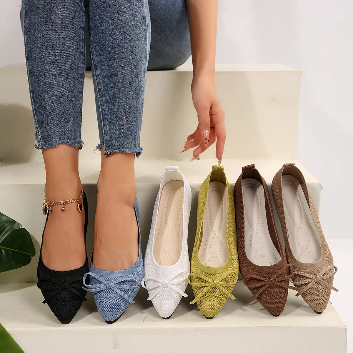 Women's blue knitted flat loafers with a bow and pointed toe on a rubber sole.