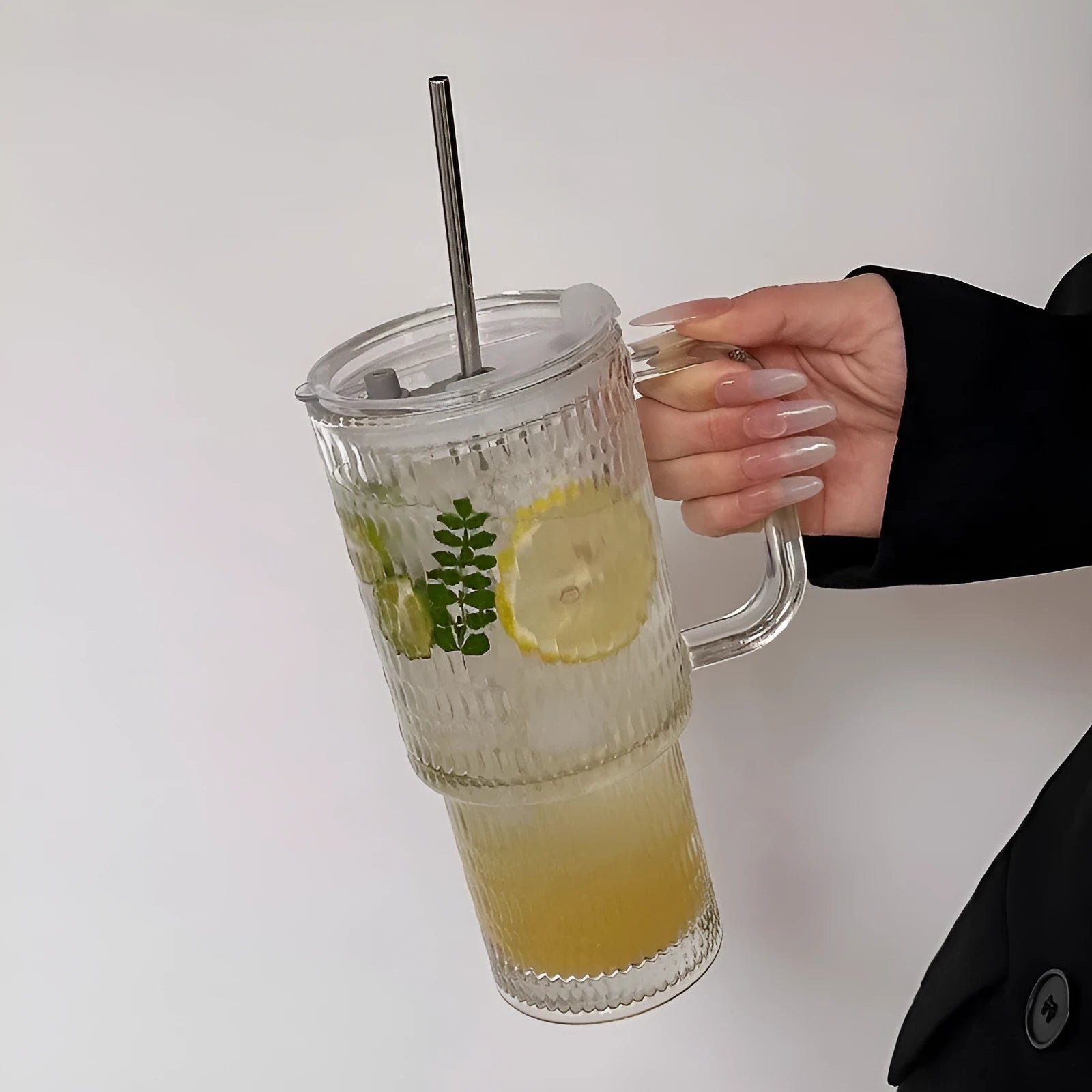 740ml round glass cup with handle, lid, and bent straw on modern table setting