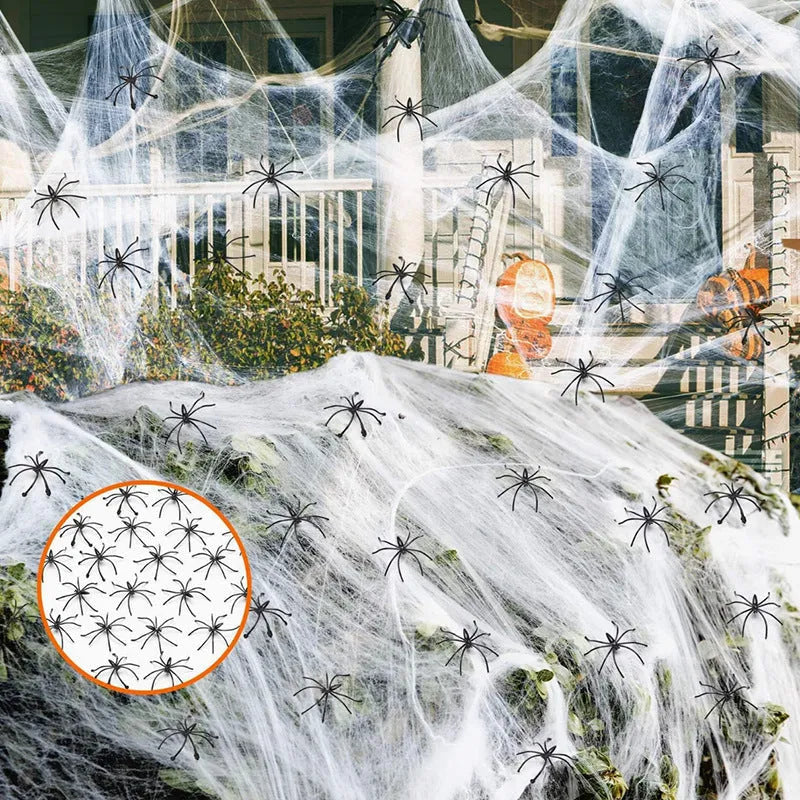 White cotton Halloween spider web decoration draped with plastic spiders for haunted house party decor.