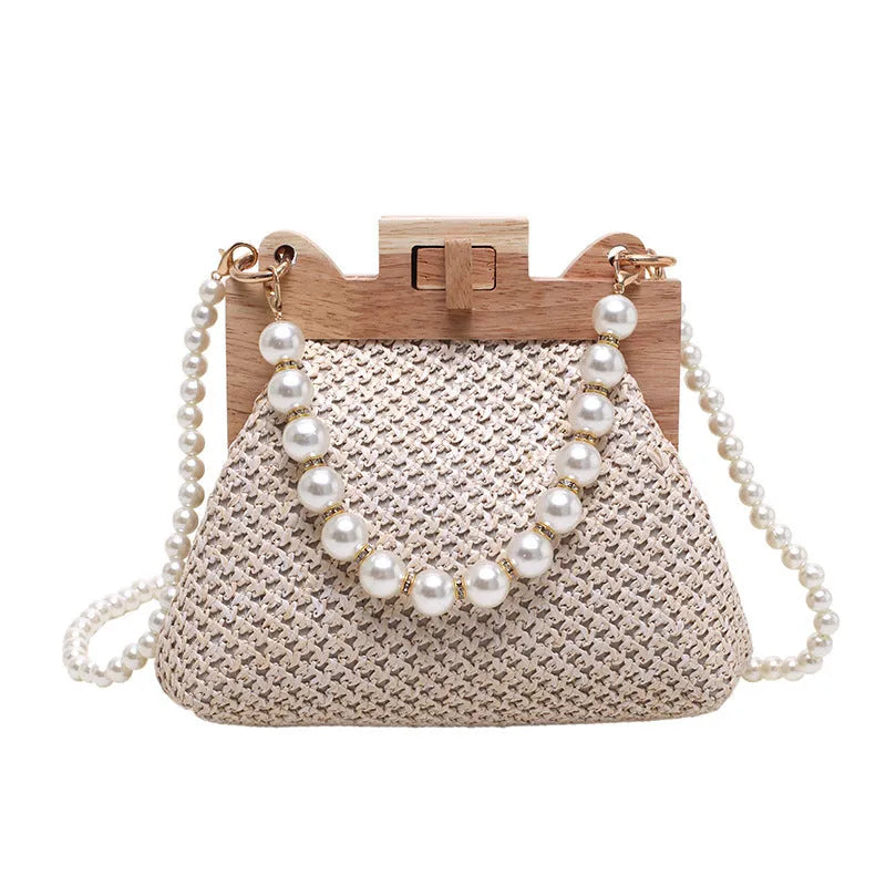 Women's woven straw shoulder bag with pearl chain strap in beige, showing internal organiser pockets.