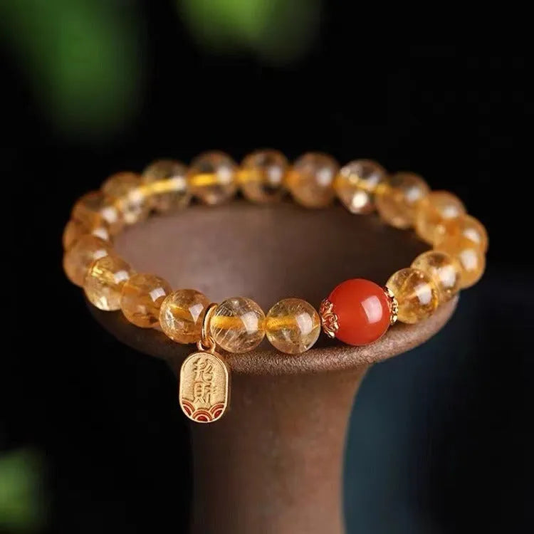 Polished natural red agate lucky beads bracelet on a wrist, showing ruby colour beads.