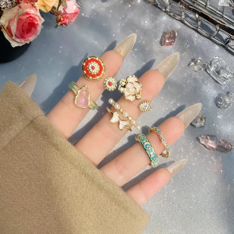 A copper vintage-style ring with a gourd motif, floral and bow designs, inlaid zircon stones, and an adjustable opening.