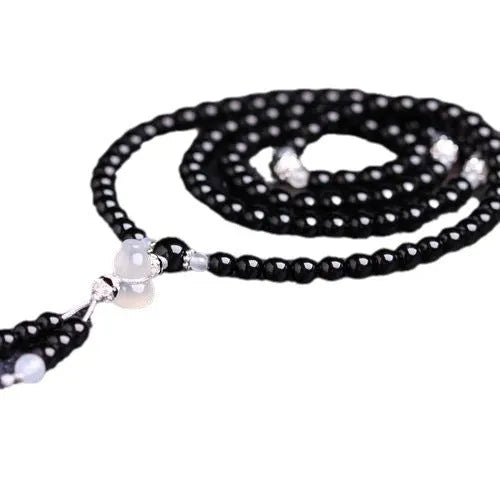 Natural black agate bracelet with 108 beads showing geometric shapes and numeric design elements