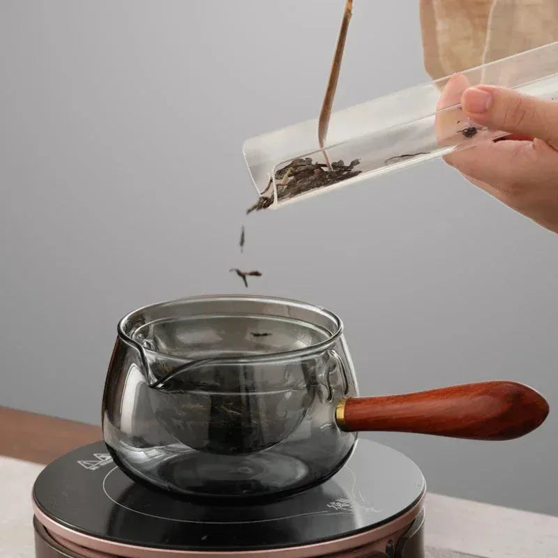 Transparent rotating glass teapot with wooden handle and integrated tea infuser