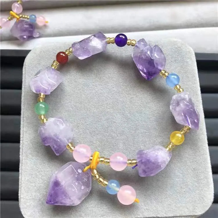 Women's amethyst bead bracelet with a Chinese fu character charm on a white background.