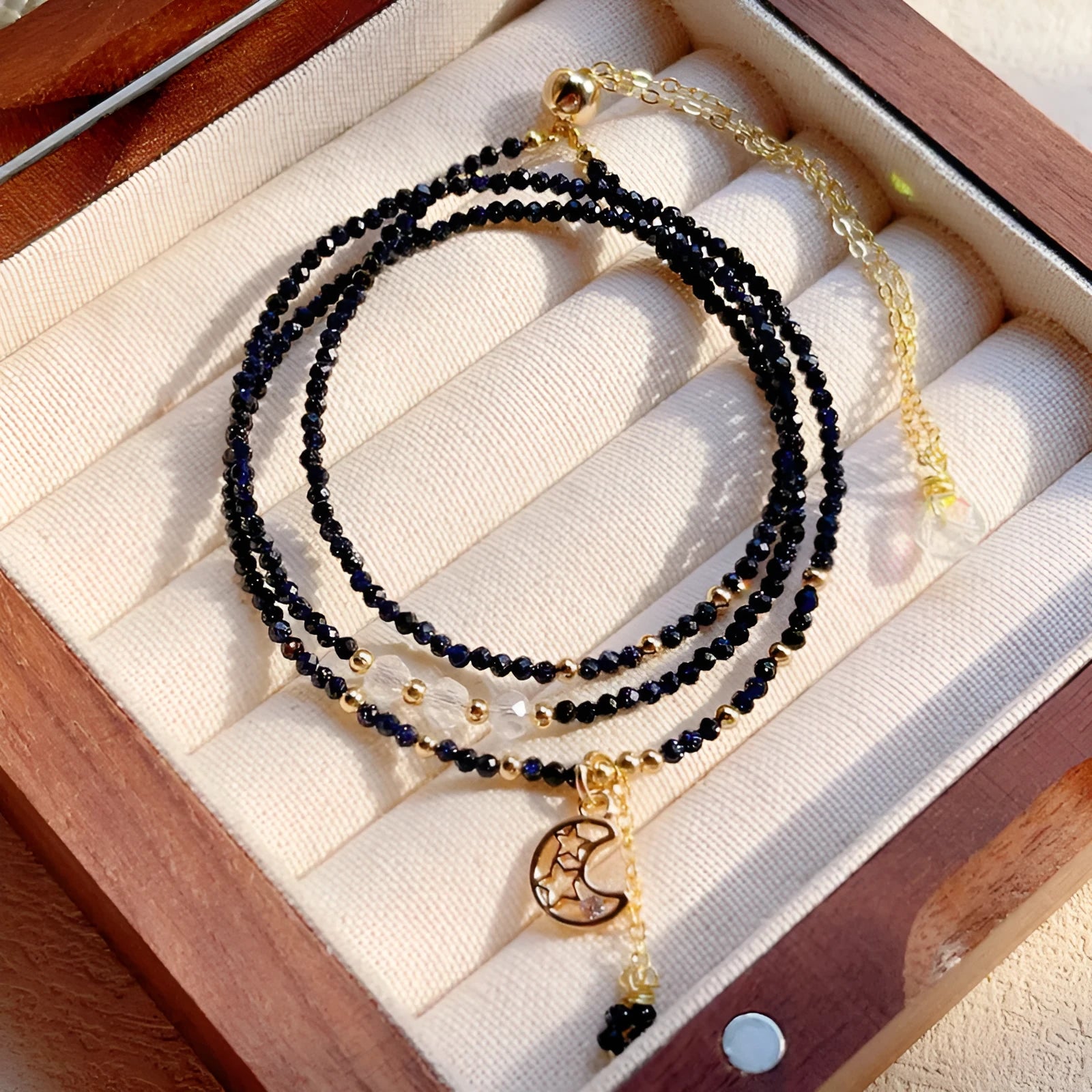 Close-up of a blue gold sand stone bracelet with three interlocking rings on a wrist.