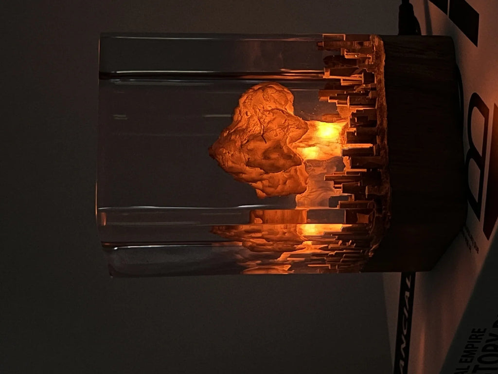 Small atomic bomb mushroom cloud shaped resin night lamp decoration in two colour variants on a dark surface.