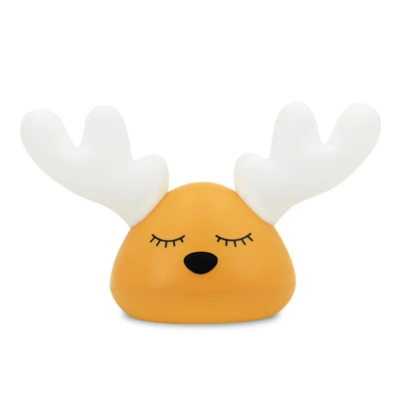 Children bedside Christmas deer night light with colour-changing LED and soft silicone shade on a table