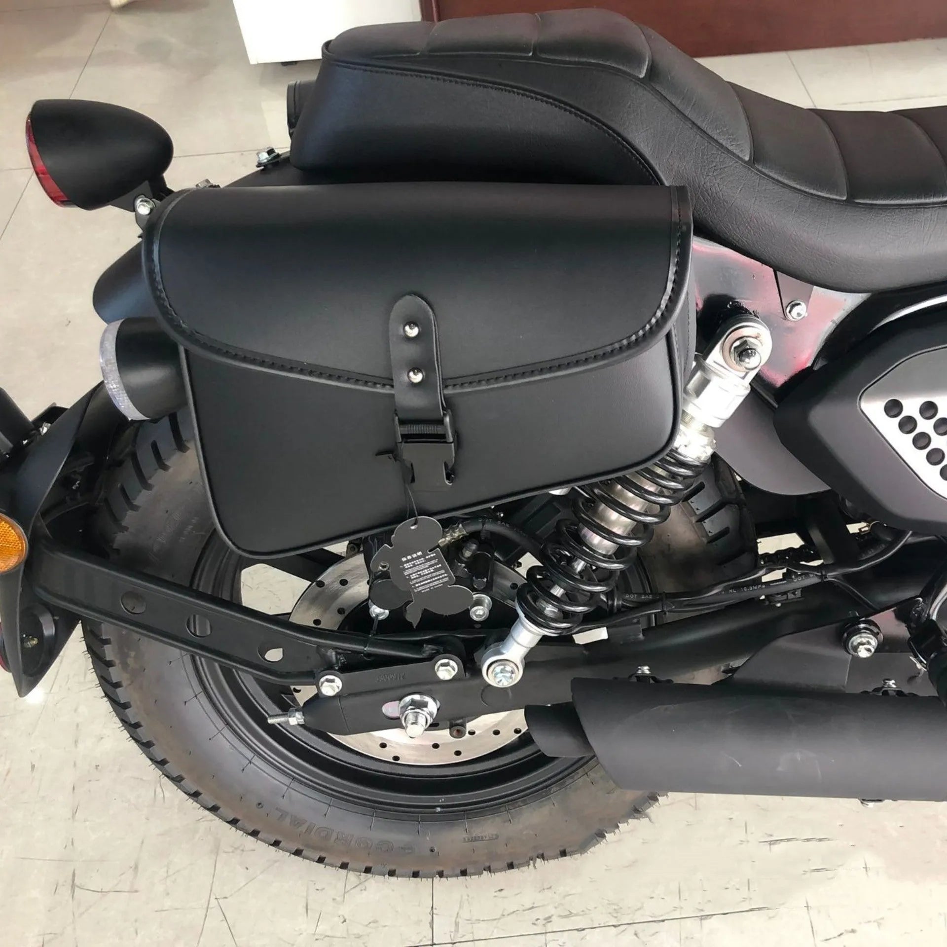 Black PU leather motorcycle swingarm bag mounted on a Harley Sportster side.