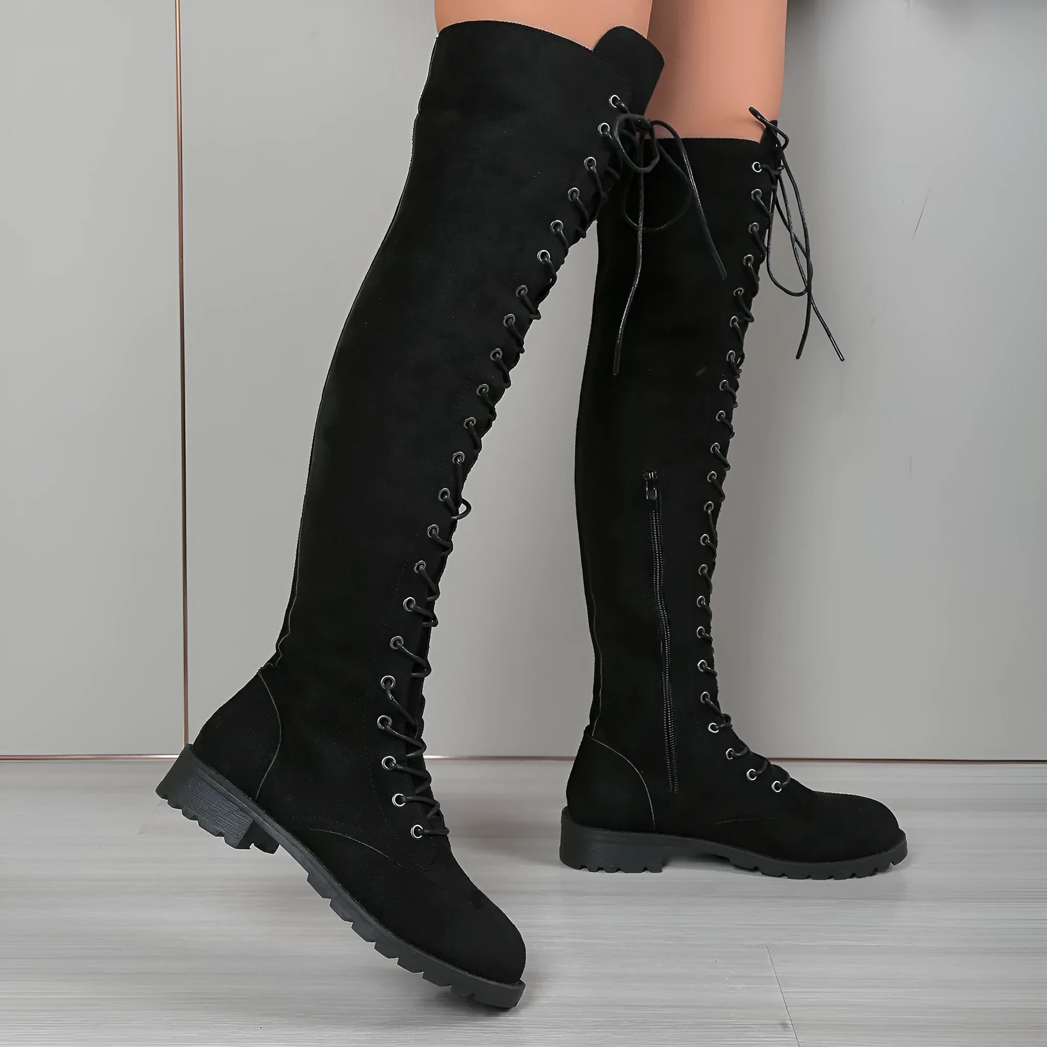 Black lace-up over-the-knee flat boots with round toe and stitching detail.