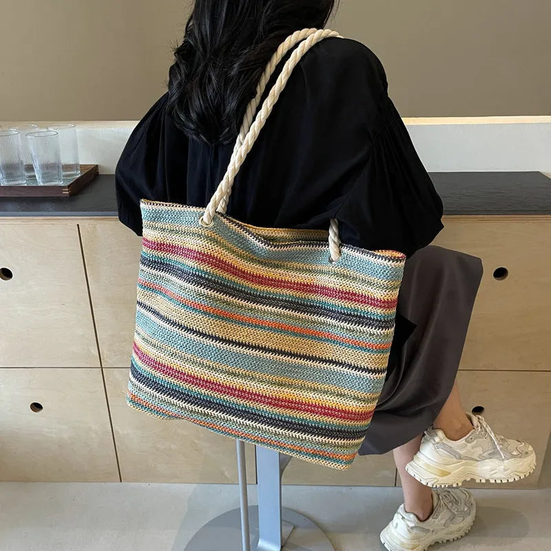 Blue woven nylon shoulder bag with single strap and straw texture.
