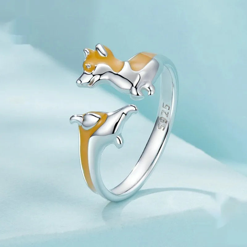 Silver ring with a raised cartoon corgi dog design on the band.