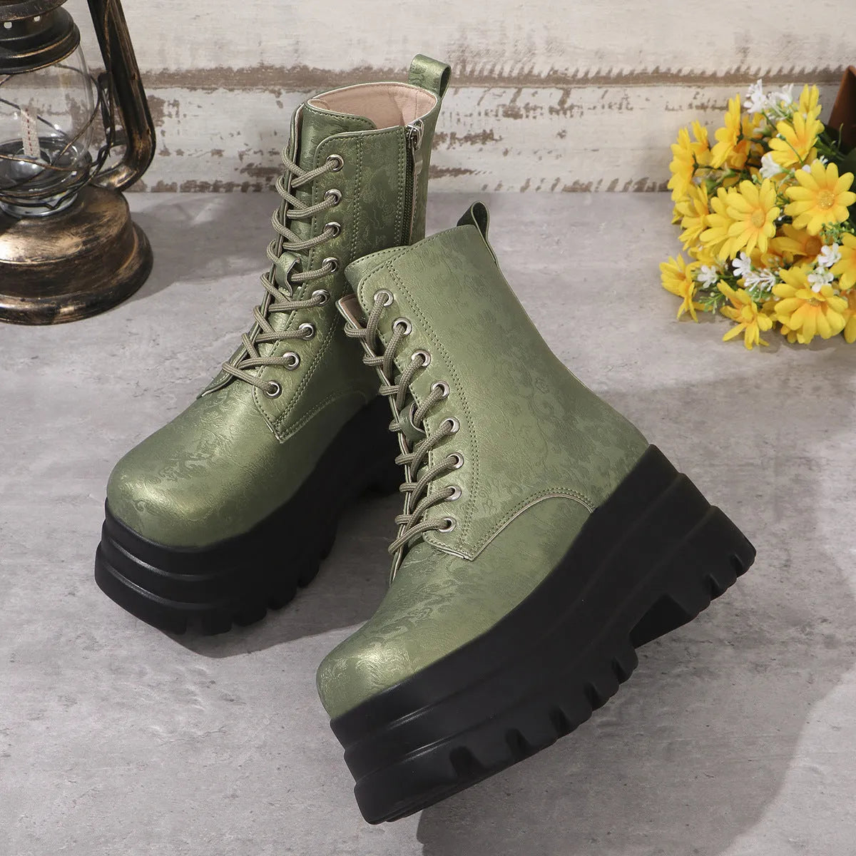 Women's black platform Martin boots with patchwork detail and side zip on a white background.