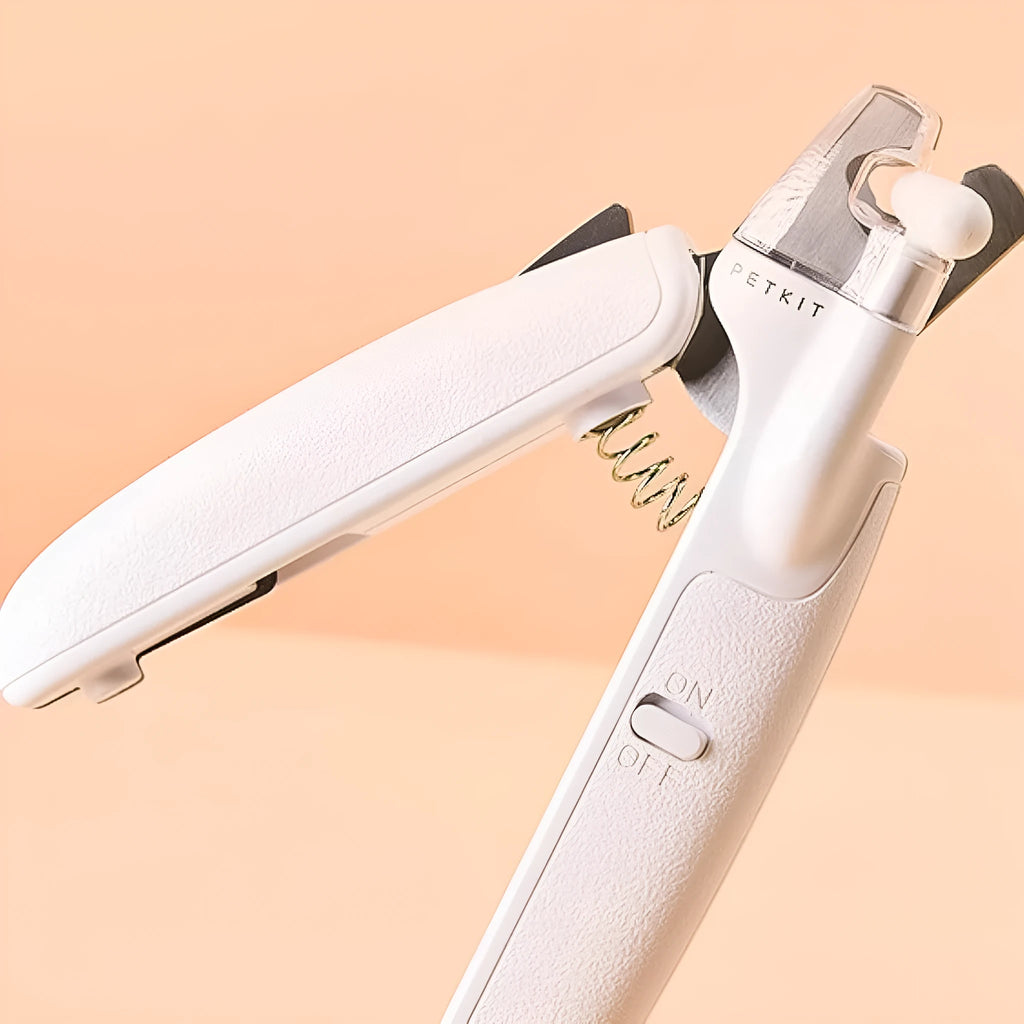 White pet nail clipper with LED light and transparent anti-splash guard on a blue background.