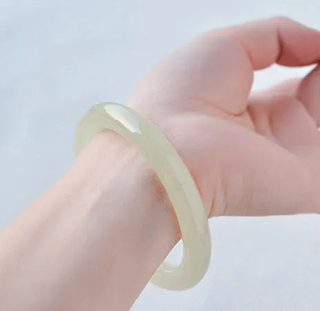 Round bar jade bracelet with winding silk texture showing circular geometry and polished surface