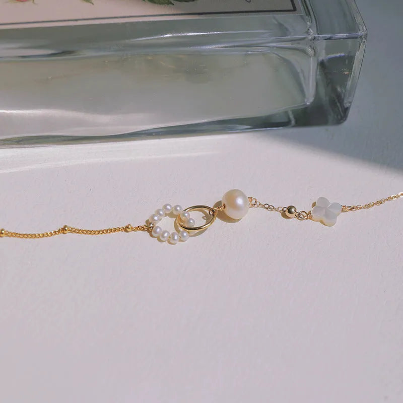 Close-up of a women's natural pearl bracelet with 14k gold-plated metal detailing.
