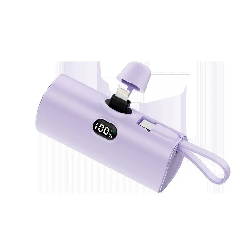 Compact black power bank with digital display and a folding AC plug extended, showing its pocket-sized dimensions.