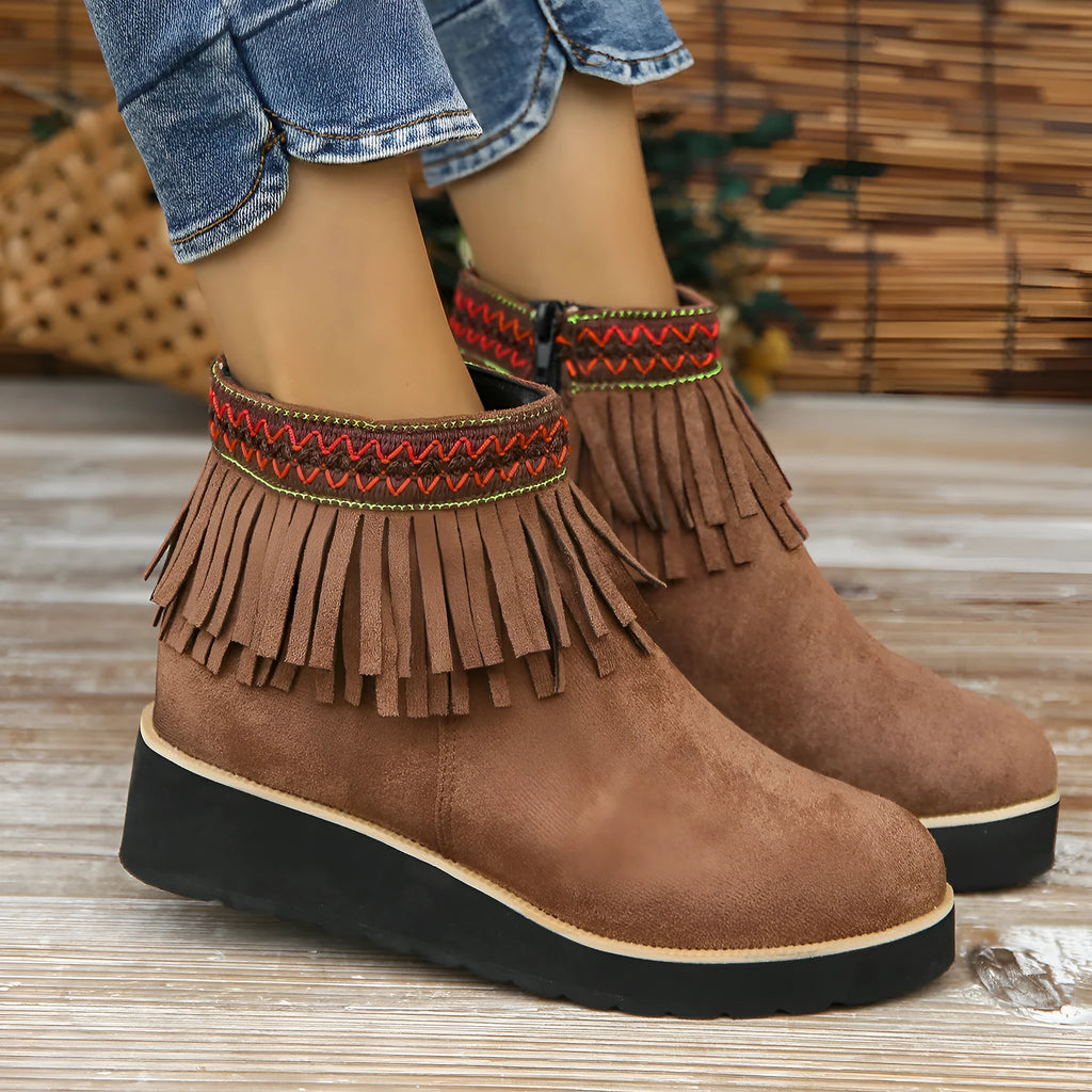 Women's black suede wedge ankle boots with side zipper, tassel detail, and thick rubber sole.