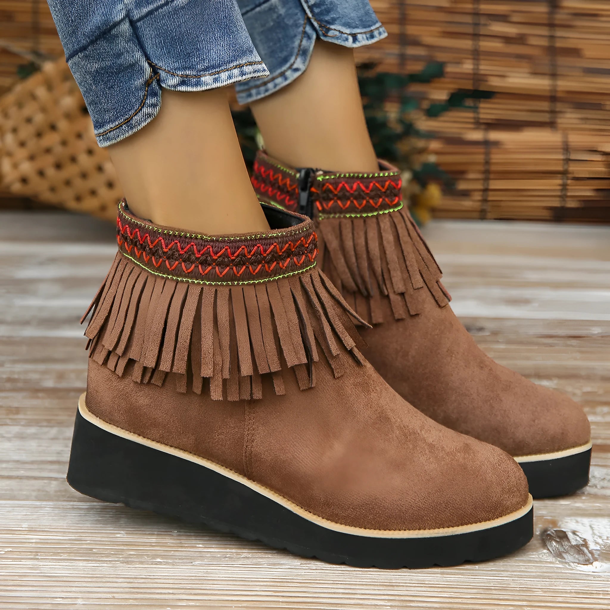 Women's black suede wedge ankle boots with side zipper, tassel detail, and thick rubber sole.
