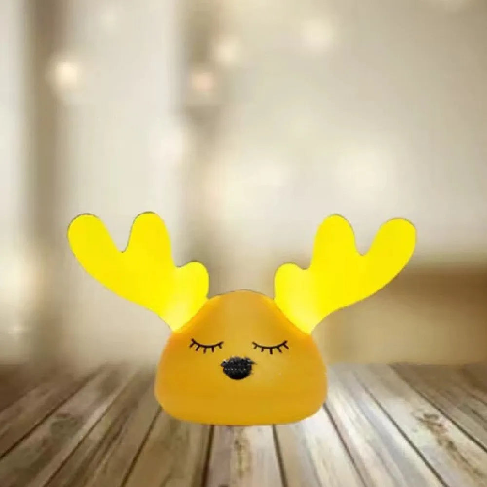 Children bedside Christmas deer night light with colour-changing LED and soft silicone shade on a table