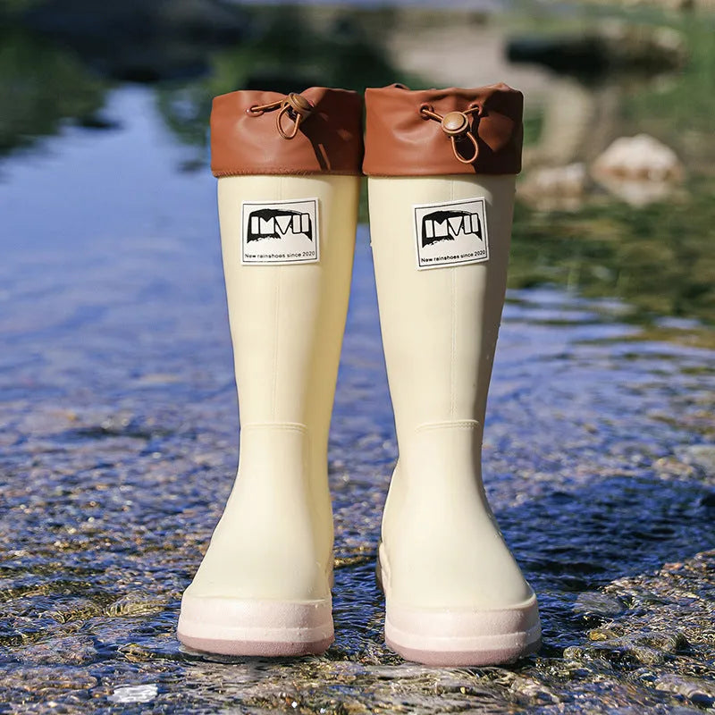 A pair of solid-colour high-tube PVC rain boots with a low heel on a plain background.