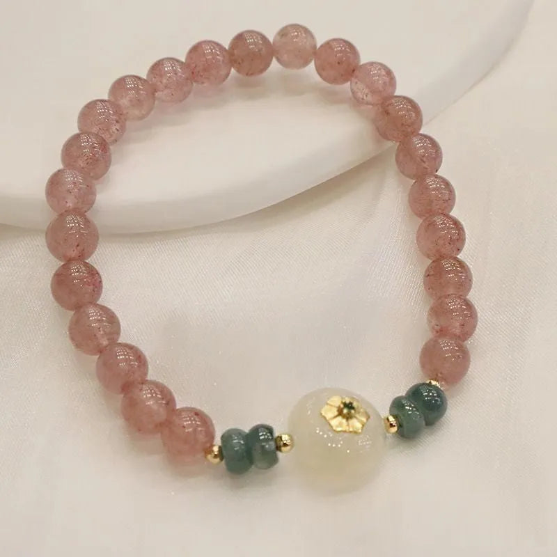 Women's strawberry quartz bracelet with blue water emerald jade pendant, geometric shapes, and traditional Chinese symbolism