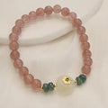 Women's strawberry quartz bracelet with blue water emerald jade pendant, geometric shapes, and traditional Chinese symbolism