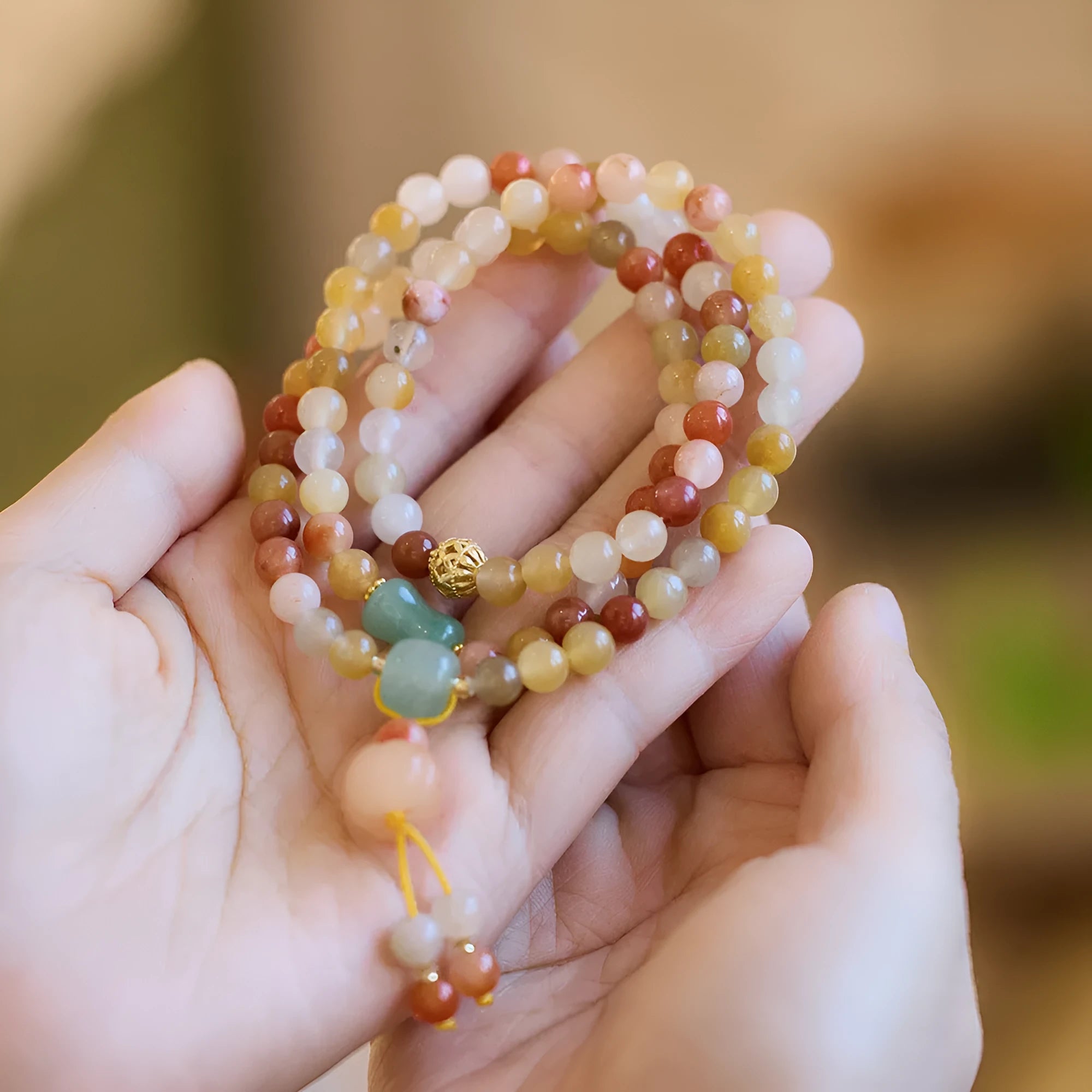 Women's green jinsi jade bracelet with golden threads and pumpkin tassel design