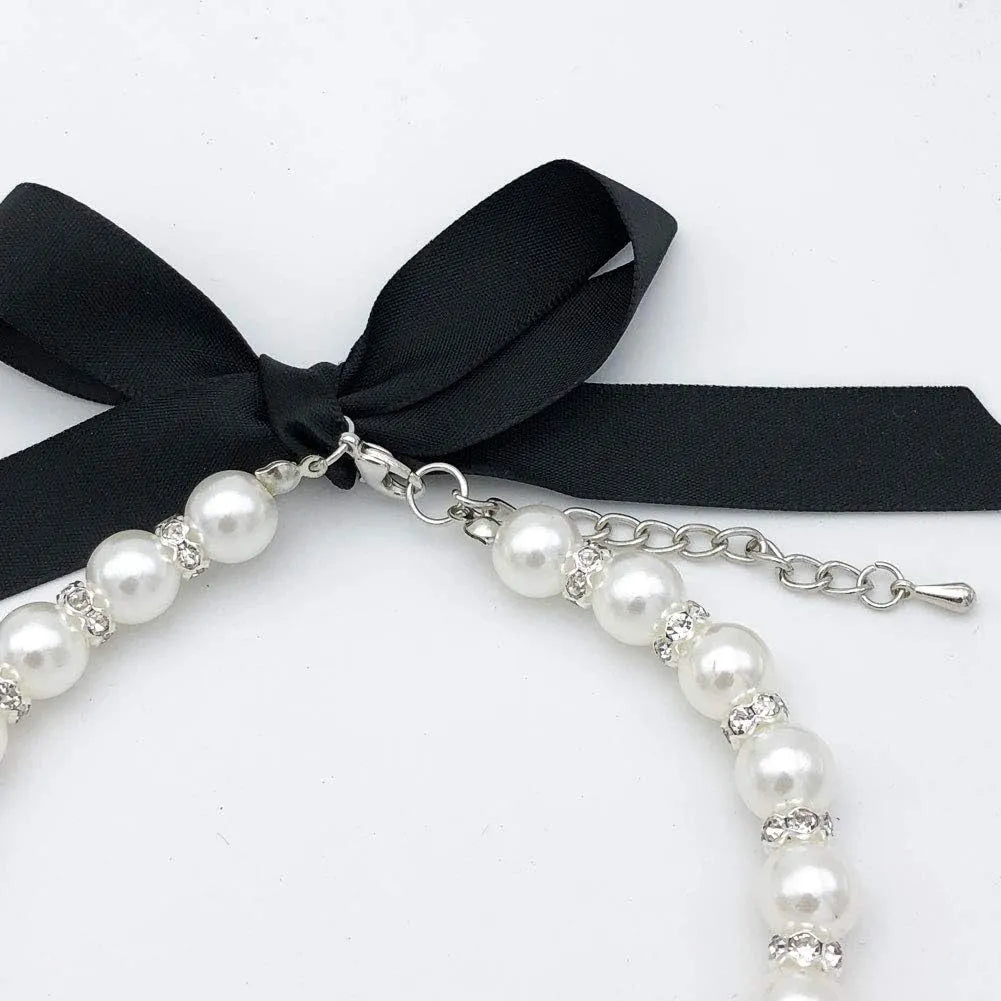 Small dog wearing adjustable pearl and rhinestone necklace with bow in blue colour