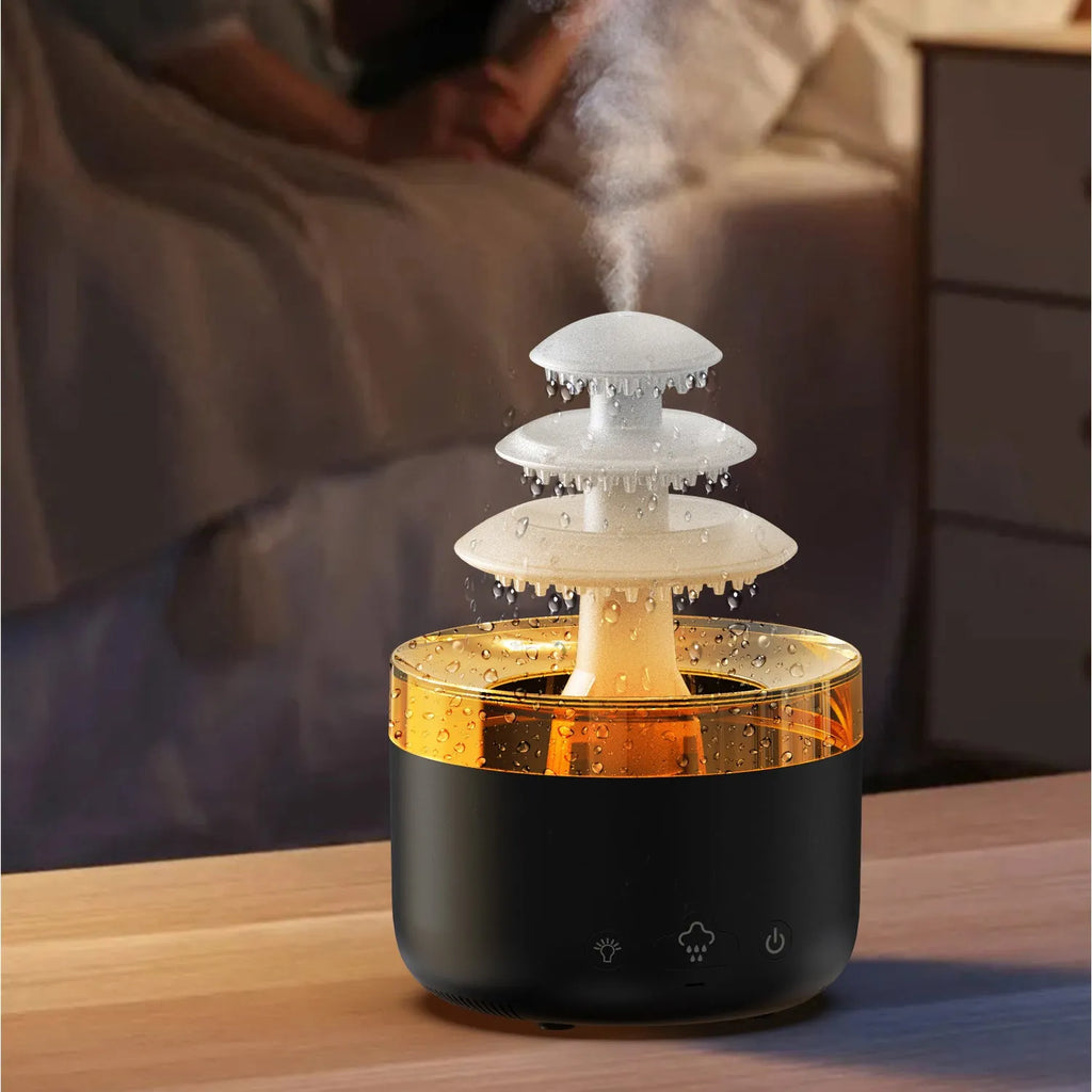 White cloud rain shape ultrasonic humidifier and essential oil diffuser with colourful LED lights on a table.