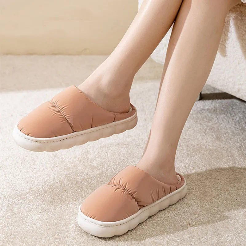 A pair of thick-soled down cotton slippers for men and women in a choice of colours, featuring a non-slip rubber sole.