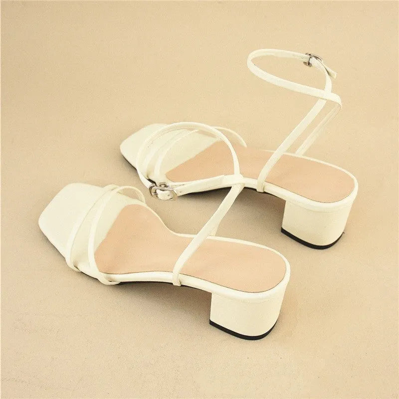 Beige women's stiletto sandals with a chunky heel, square toe, and an ankle buckle strap.