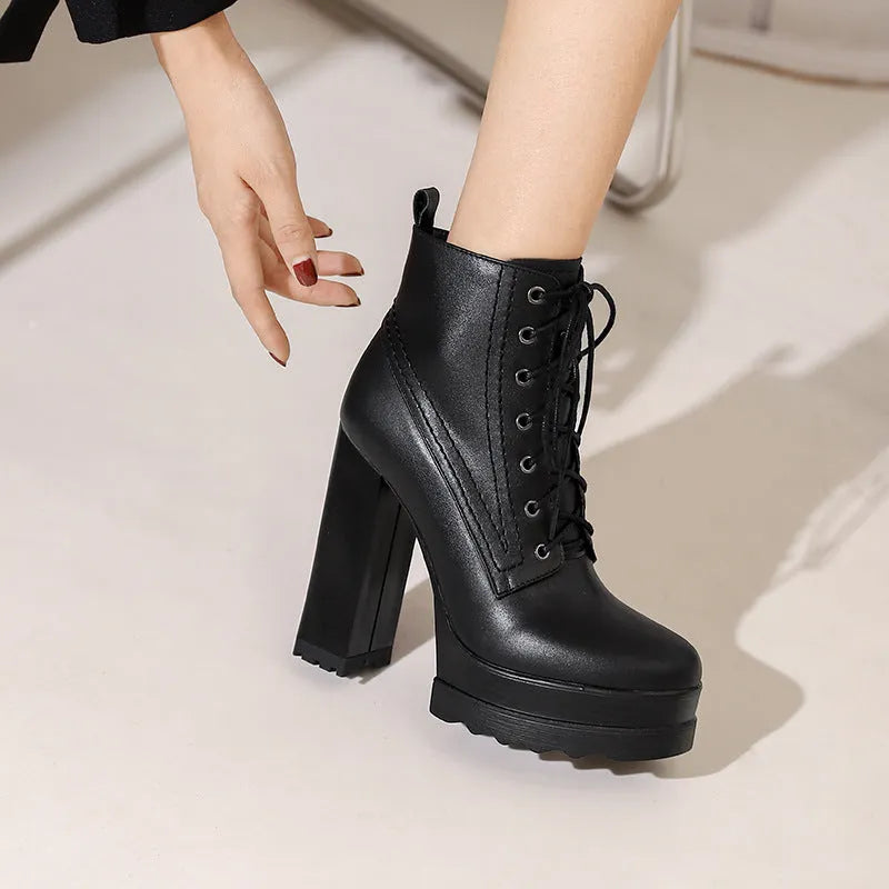 Women's black waterproof platform boots with a chunky heel and side zip fastening on a white background.