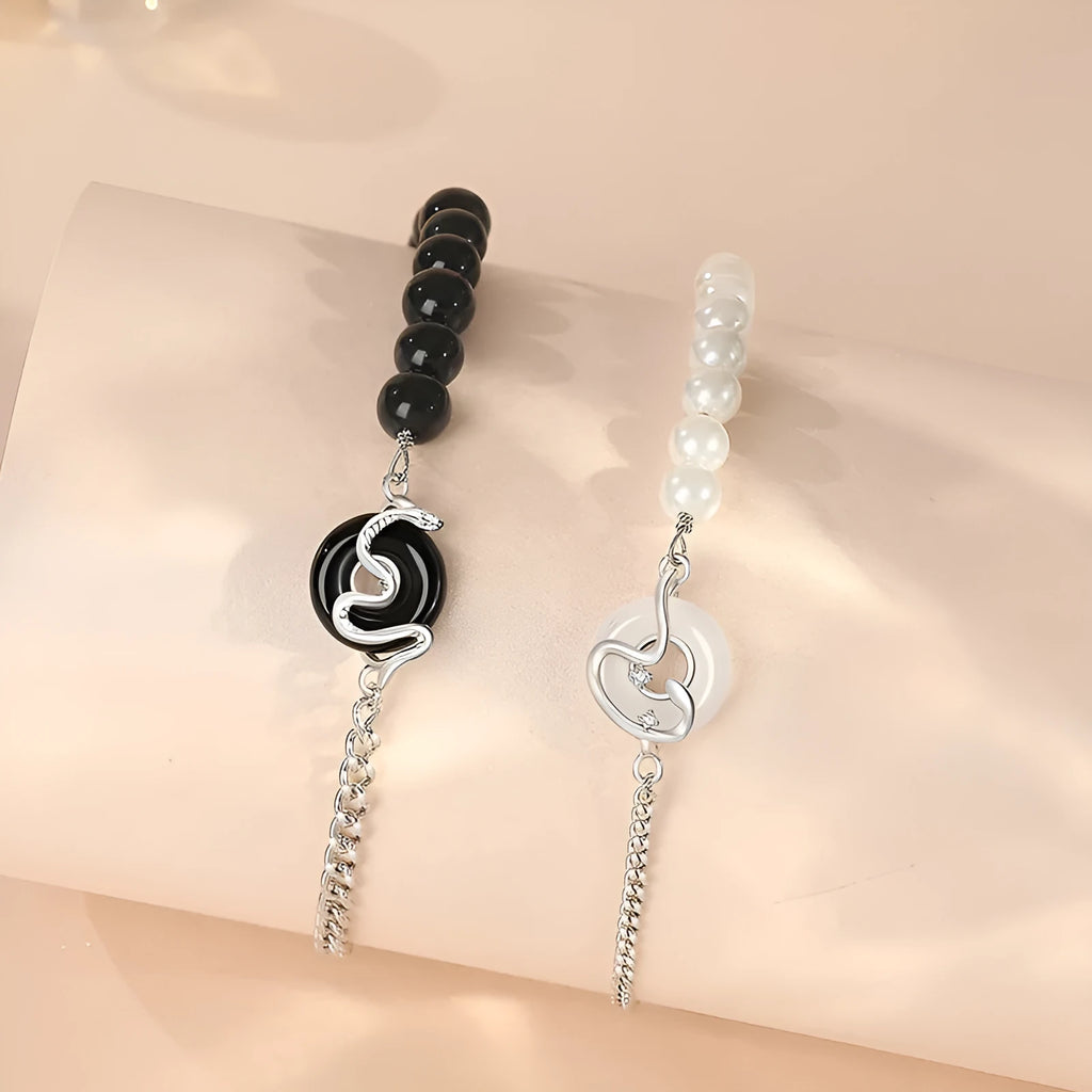 A New Chinese style 925 sterling silver couple's bracelet with a safe buckle, snake motif, and a central obsidian pearl.