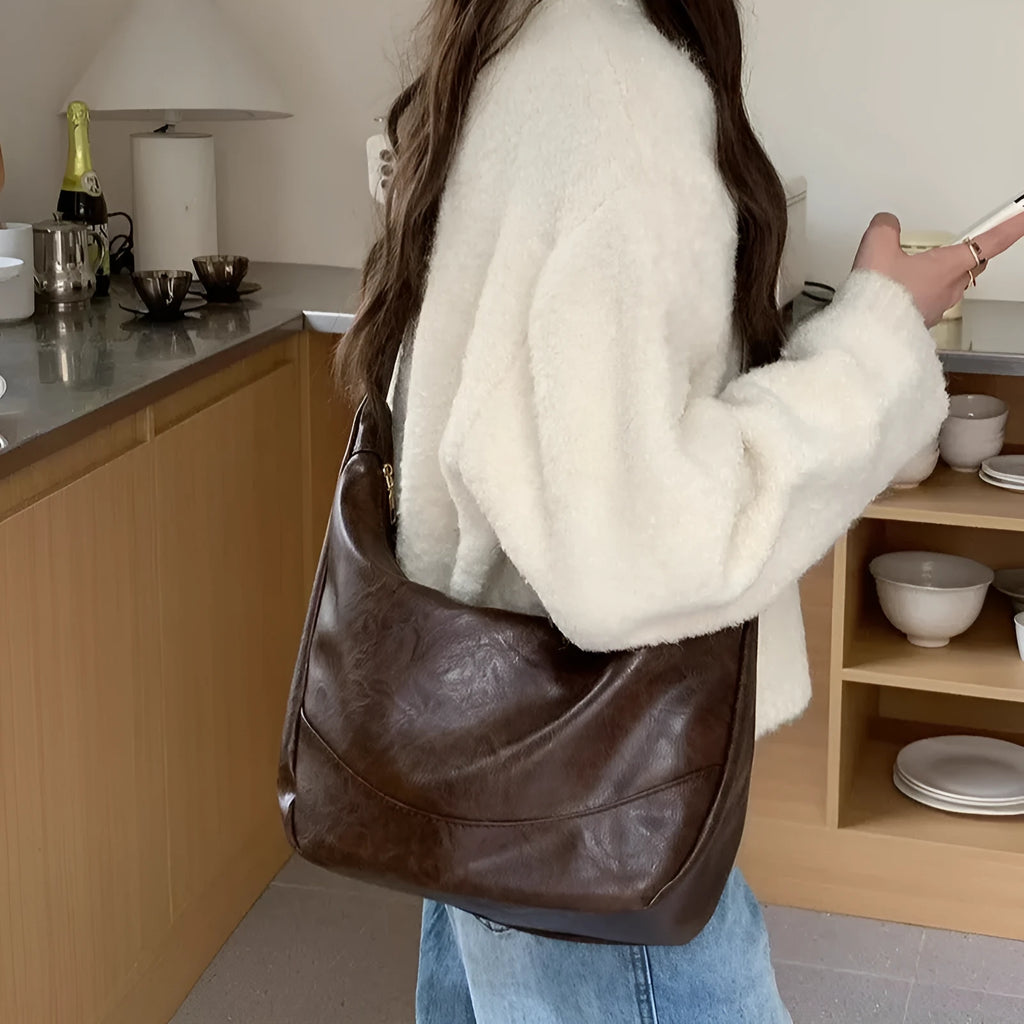 Female retro casual large capacity single shoulder crossbody bag in PU leather, brown, with sewing line detail and dumpling shape