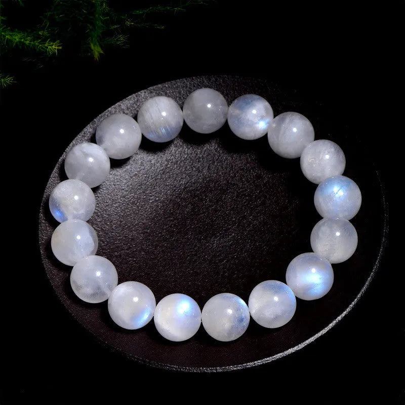 Natural white Moonstone round bead bracelet on a wrist, showing polished geometry beads.