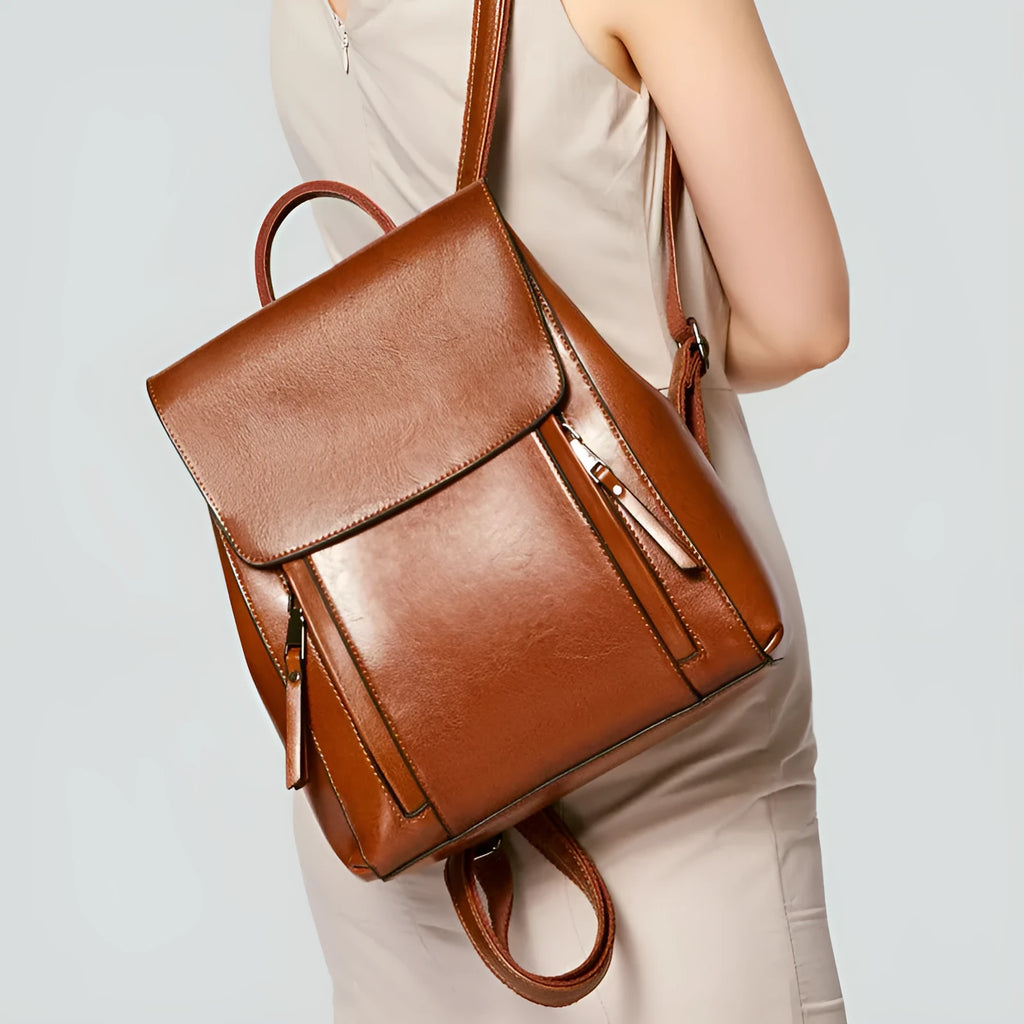 Large black square leather women's backpack with double straps and a cover opening.