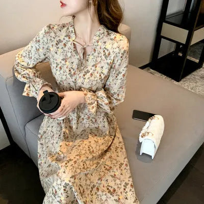 Retro waist-cinching floral A-line dress in apricot colour with princess-style seams, shown on a woman