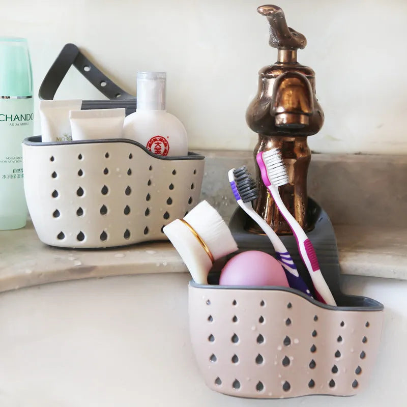 Three plastic kitchen sink storage racks in beige light blue and light pink on a draining board