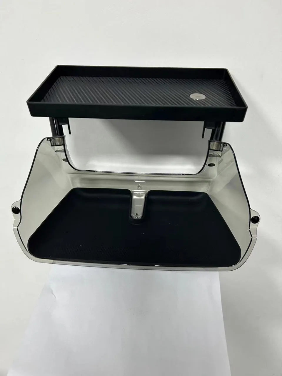Black ABS plastic storage box fitted under the touchscreen of a Tesla Model Y interior.