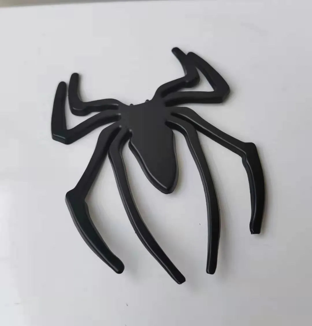 Three-dimensional metal spider bumper sticker in metallic finish measuring 7cm by 5cm