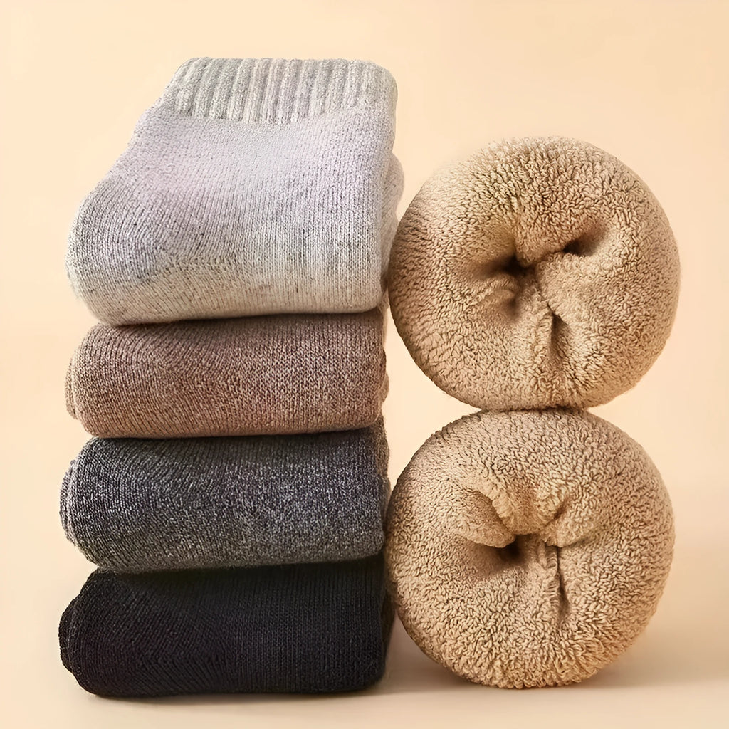 Two pairs of thick, solid-colour wool socks with a winter midsole, shown in cold-resistant cashmere colour options.