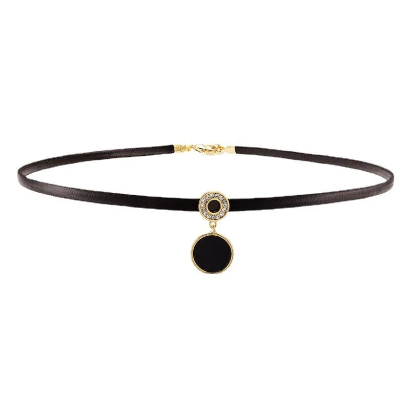 Women's short black clavicle necklace with round gold alloy pendant and leather rope chain on display