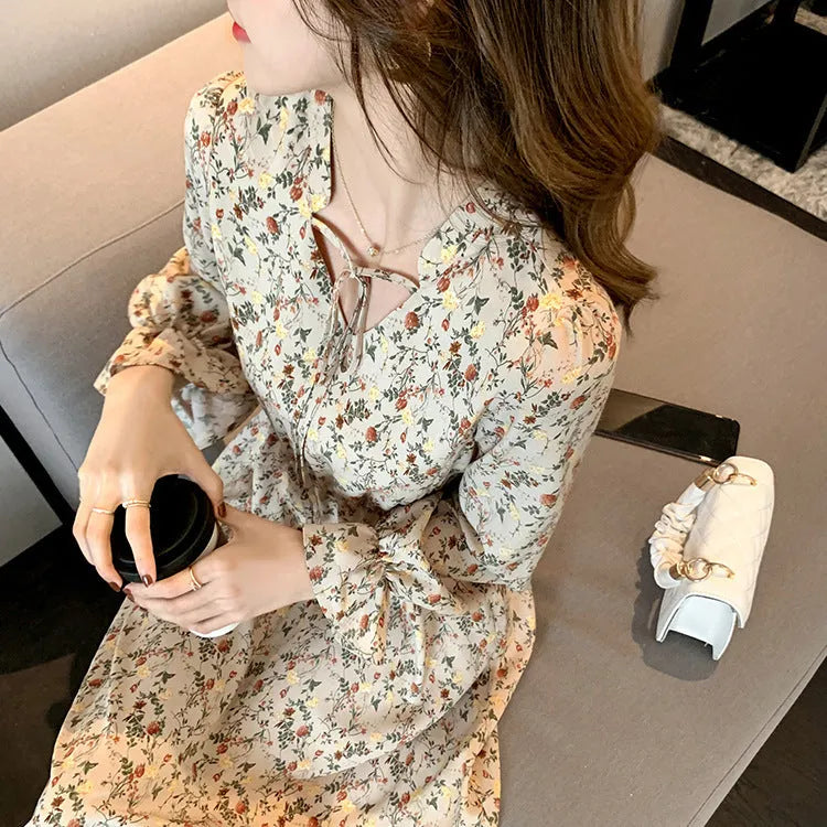 Retro waist-cinching floral A-line dress in apricot colour with princess-style seams, shown on a woman