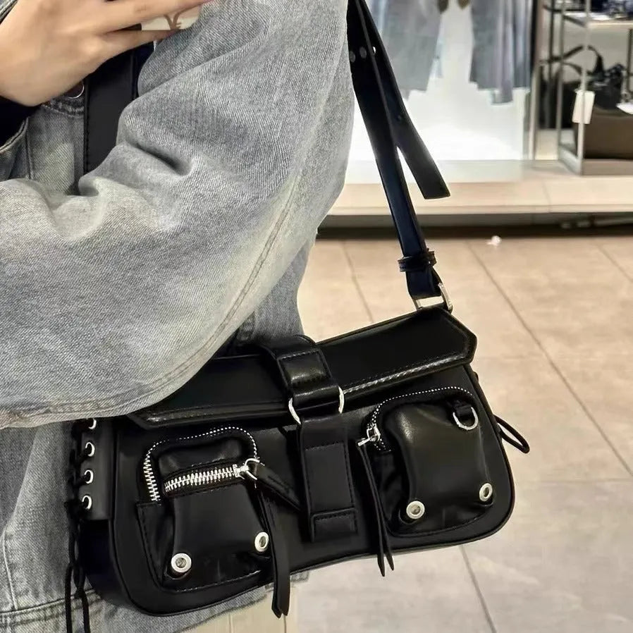 Black women's underarm baguette messenger bag with single shoulder strap showing interior zipper pocket