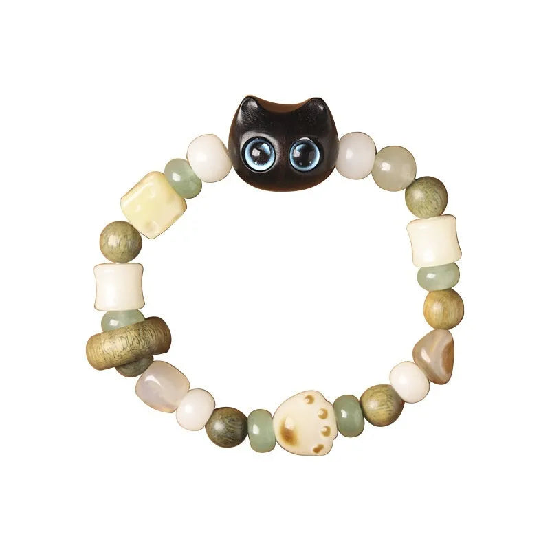 Hand-woven cat paw bracelet with a jade, bodhi seed, and ebony multi-treasure cube charm.