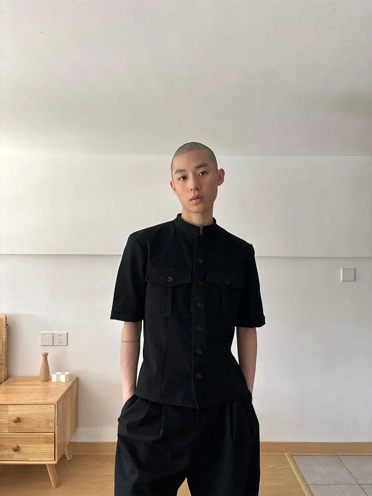 Black handmade loose-fit half sleeve hunting shirt with a shirt collar on a hanger.