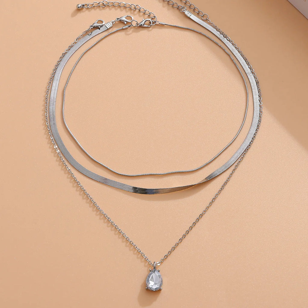 Gold and silver water drop shape alloy pendant necklace with electroplated finish on white background